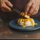 hands placing chicken patty on rice